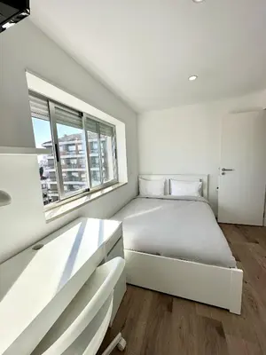 a white bedroom with a bed and a window at Fantástico T3 Porto - 6 Pessoas - Novo in Porto