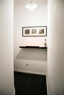 a hallway with a black tile floor and a shelf at Oporto Central Flat - Downtown in Porto