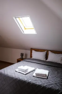 a bedroom with a bed with towels and a skylight at Casas da Corujeira 2 in Porto