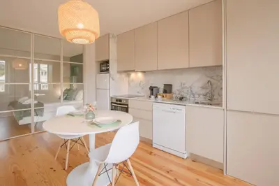 a kitchen with white cabinets and a table and chairs at NEW - Bright Studio in Santa Catarina in Porto