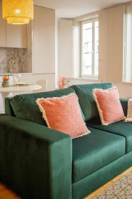 a green couch with pink pillows in a living room at NEW - Bright Studio in Santa Catarina in Porto