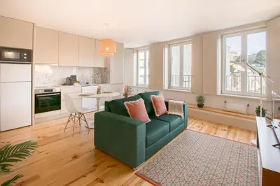 a living room with a green couch and a kitchen at NEW - Bright Studio in Santa Catarina in Porto
