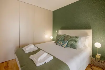 a bedroom with a large white bed with green walls at NEW - Bright Studio in Santa Catarina in Porto