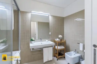 a bathroom with a sink and a mirror and a toilet at Cardosas Story Apartments by Porto City Hosts in Porto