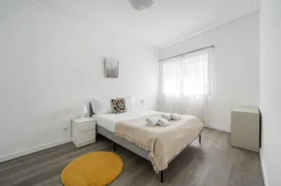 a white bedroom with a bed and a window at GuestReady - A sunny moment in Porto in Porto