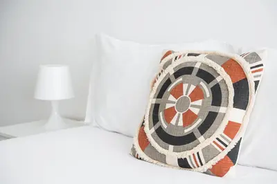 a bed with a dart pillow on it at GuestReady - A sunny moment in Porto in Porto