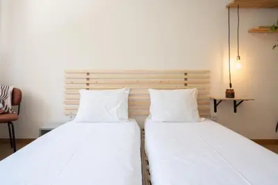 two beds sitting next to each other in a room at Jardim do Morro Apartment By Porto Stories in Vila Nova de Gaia