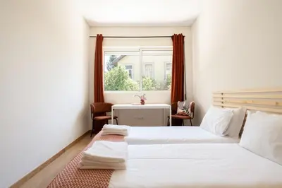 a bedroom with two beds and a window at Jardim do Morro Apartment By Porto Stories in Vila Nova de Gaia