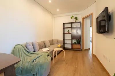 a living room with a couch and a tv at Jardim do Morro Apartment By Porto Stories in Vila Nova de Gaia