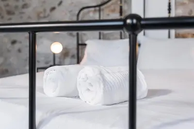 a pile of towels sitting on a bed at PortoNest Downtown Studios in Porto