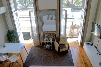 a living room with a bed and a mirror at Apartment Oportoloft in Porto
