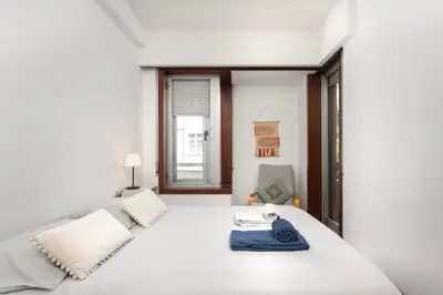 a bedroom with a large white bed and a window at Porto Cozy Space in Porto