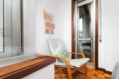 a chair sitting in a room next to a window at Porto Cozy Space in Porto