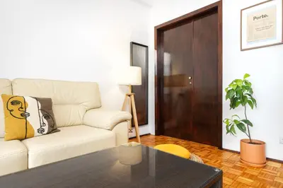 a living room with a white couch and a table at Porto Cozy Space in Porto