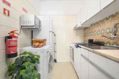 a kitchen with a washing machine and a sink at Porto Cozy Space in Porto
