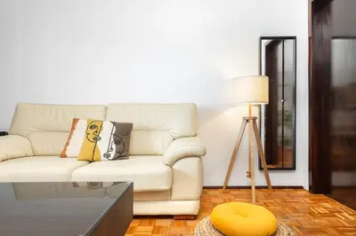 a living room with a white couch and a table at Porto Cozy Space in Porto
