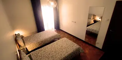 a mirror in a room with two beds and a mirror at Gulbenkian 39 in Vila Nova de Gaia