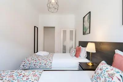 a bedroom with two beds and a bowl of fruit on a table at Host Wise - Comfy Minimalist Flat in Porto