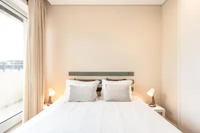 a white bedroom with a large bed with white pillows at VIVA Peaceful Zen Retreat in Porto