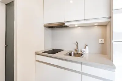 a kitchen with white cabinets and a sink at VIVA Peaceful Zen Retreat in Porto