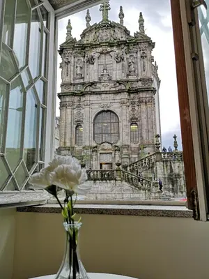 a vase with a flower in front of a building at Clérigos Ville Porto Rooms in Porto