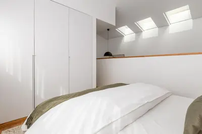 a bedroom with white walls and windows and a bed at Urban Loft in Porto