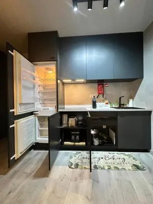 a kitchen with black cabinets and an open refrigerator at Porto Charme Residence in Porto