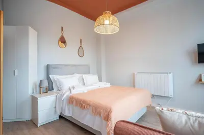 a white bedroom with a bed and a chair at Marquês Studio by Amber Star Rent in Porto