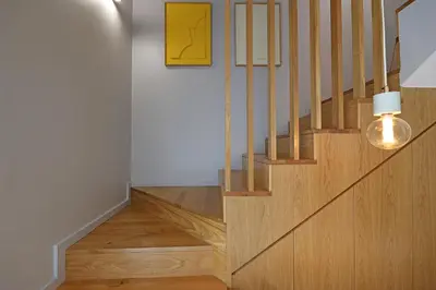 a wooden staircase with a light on the side at FLH Boavista Woody Duplexes in Porto