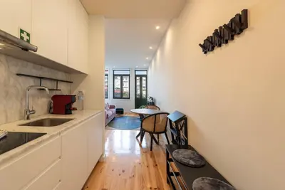 a kitchen with white cabinets and a table at Chic Porto Hideaway: Pool & Garden in Porto