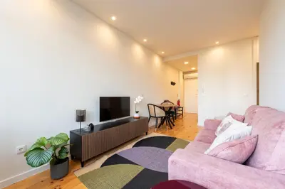 a living room with a pink couch and a tv at Chic Porto Hideaway: Pool & Garden in Porto