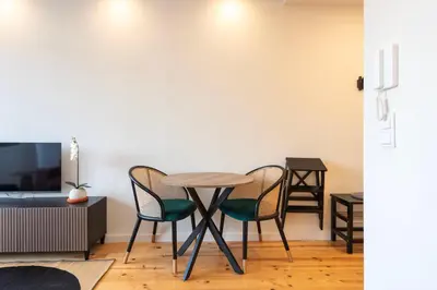 a table and chairs in a living room with a tv at Chic Porto Hideaway: Pool & Garden in Porto