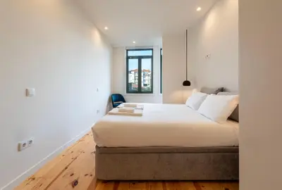 a bedroom with a large bed and a window at Chic Porto Hideaway: Pool & Garden in Porto