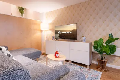 a living room with a couch and a tv on a wall at Host Wise - Central Duplex House - Terrace in Vila Nova de Gaia