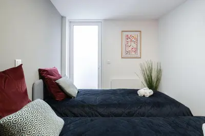 a bedroom with a bed with a blue comforter at Host Wise - Central Duplex House - Terrace in Vila Nova de Gaia