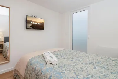 a bedroom with a bed with two white shoes on it at Host Wise - Central Duplex House - Terrace in Vila Nova de Gaia