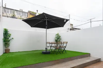 a patio with a table and chairs and an umbrella at Host Wise - Central Duplex House - Terrace in Vila Nova de Gaia