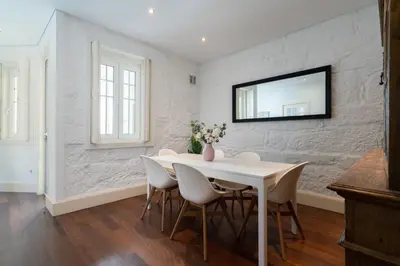 a white dining room with a white table and chairs at Host Wise - Rustic Central Flats in Porto