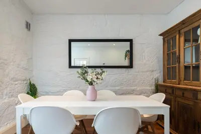 a white table with white chairs and a vase with flowers at Host Wise - Rustic Central Flats in Porto