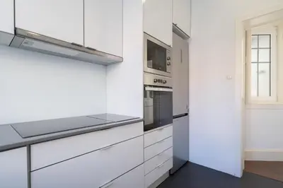 a kitchen with white cabinets and a microwave at Host Wise - Rustic Central Flats in Porto