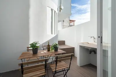 a small kitchen with a wooden table and two chairs at Host Wise - Rustic Central Flats in Porto