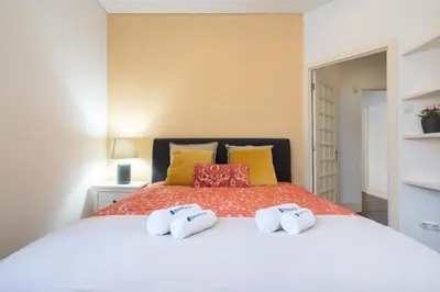 a bedroom with a bed with two towels on it at Host Wise - Rustic Central Flats in Porto