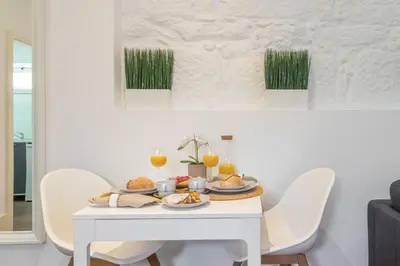 a white table with plates of food on it at Host Wise - Rustic Central Flats in Porto