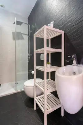 a bathroom with a white sink and a toilet at Host Wise - Rustic Central Flats in Porto