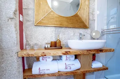 a bathroom with a sink and a mirror and towels at Authentic Porto Suites in Porto