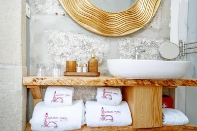 a bathroom with a counter with towels and a sink at Authentic Porto Suites in Porto