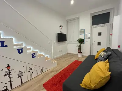 a living room with a black couch and stairs at Oporto Blue Boavista - Deluxe City Center Duplex in Porto