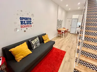 a living room with a black couch and a red rug at Oporto Blue Boavista - Deluxe City Center Duplex in Porto