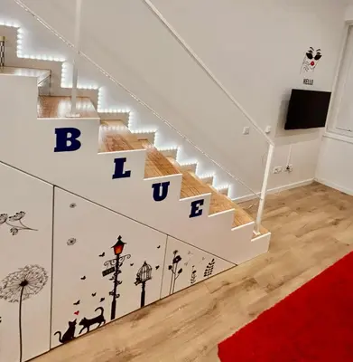 a living room with stairs with letters on the wall at Oporto Blue Boavista - Deluxe City Center Duplex in Porto