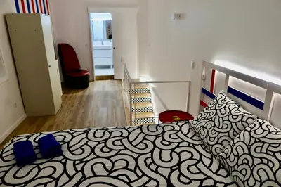 a bedroom with a bed with a black and white blanket at Oporto Blue Boavista - Deluxe City Center Duplex in Porto